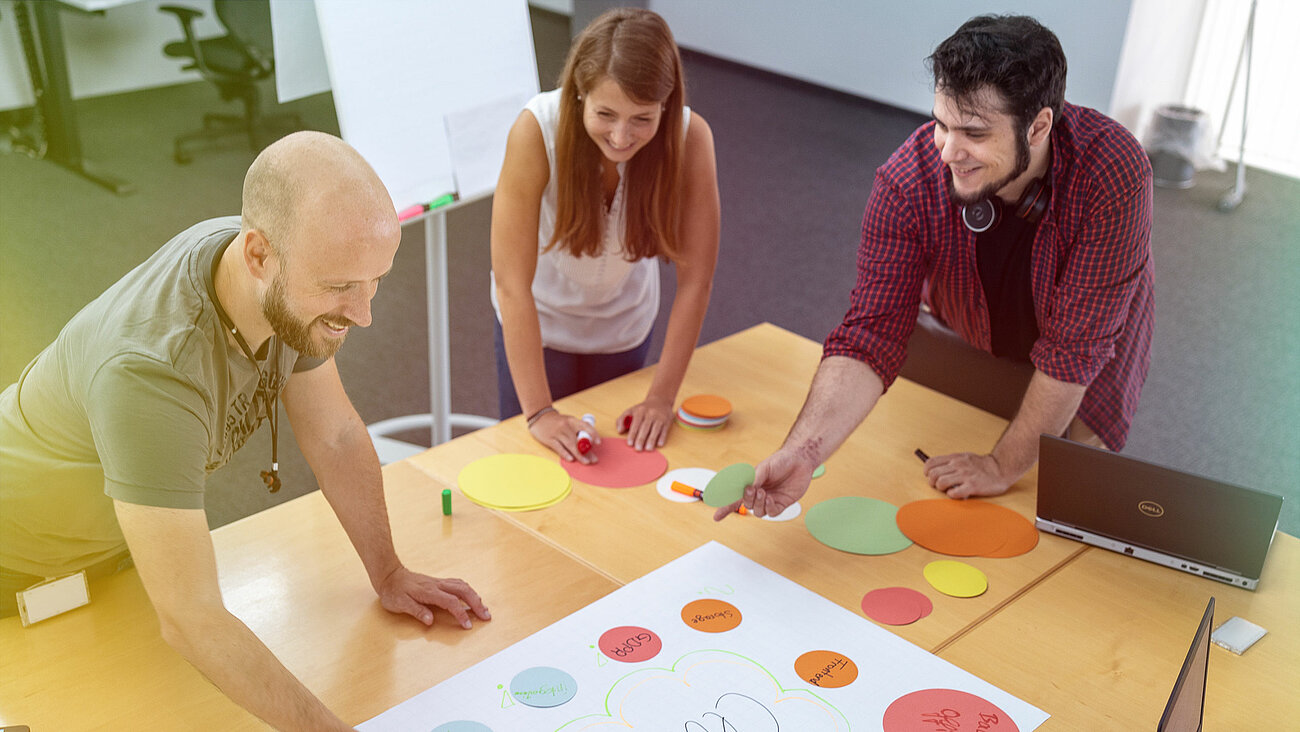 Personen arbeiten zusammen in einem Besprechungsraum.